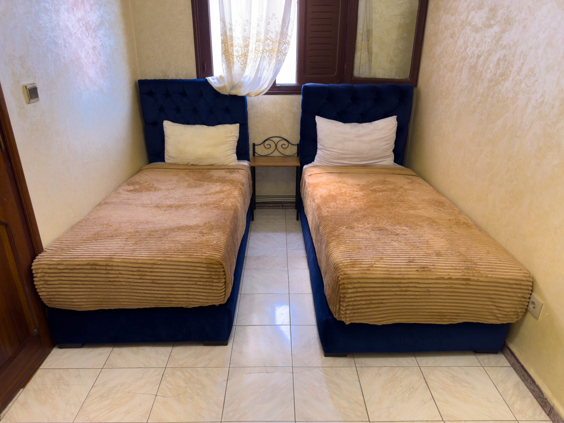 Chambre double du Casa Medina Sanaa avec tête de lit capitonnée bleue